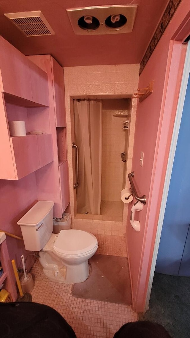 bathroom featuring tile patterned flooring, toilet, and curtained shower