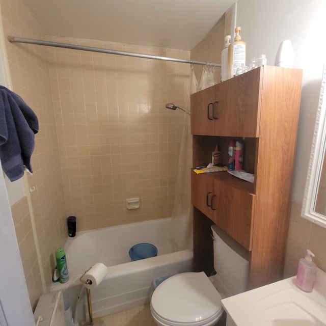 bathroom featuring tiled shower / bath combo and toilet