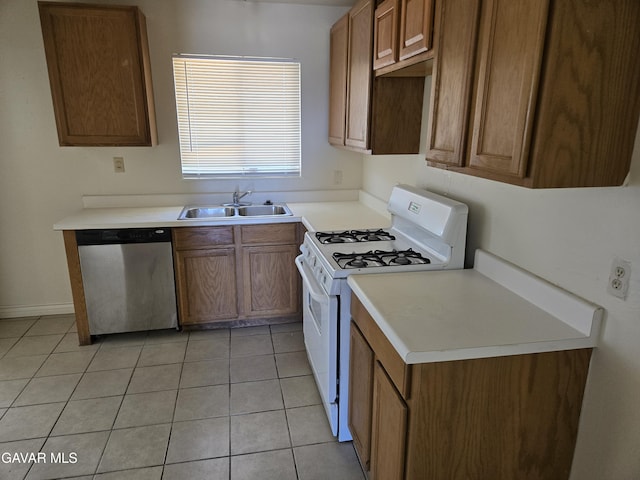 44960 E 3rd St, Lancaster, CA 93535 - kitchen with stainless steel dishwasher, white gas stove, light tile patterned floors, and brown cabinetry
