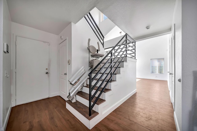 stairs featuring wood-type flooring and vaulted ceiling