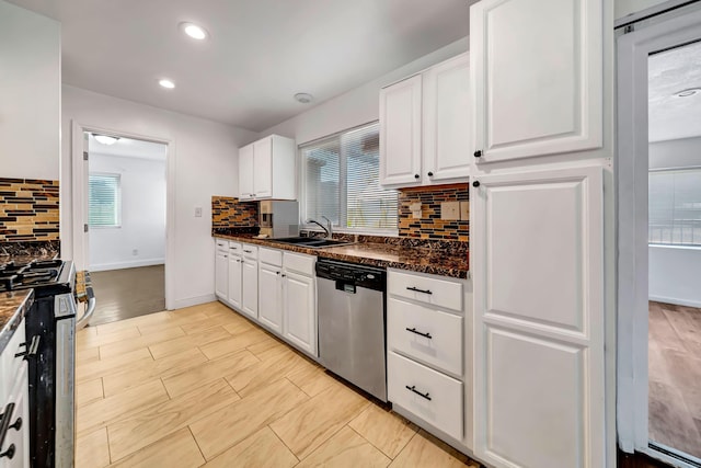 kitchen with backsplash, sink, dark stone countertops, white cabinetry, and stainless steel appliances