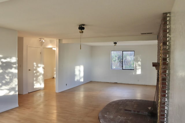 unfurnished room with a fireplace and light wood-type flooring