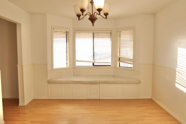 spare room with light hardwood / wood-style flooring and an inviting chandelier