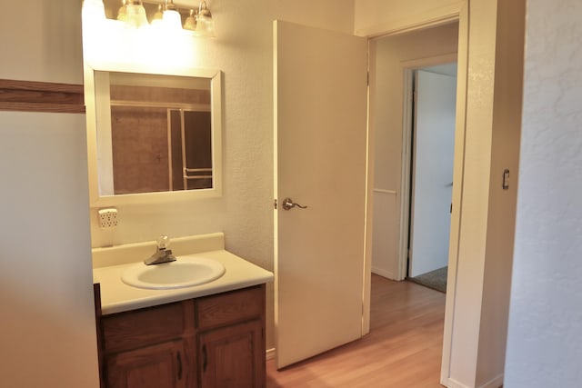 bathroom with vanity, wood-type flooring, and walk in shower