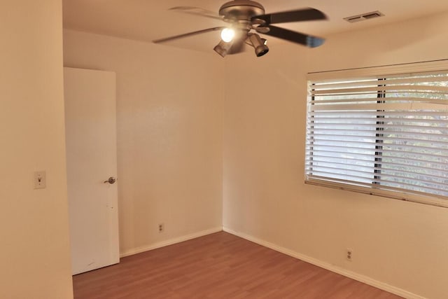 empty room with hardwood / wood-style floors and ceiling fan