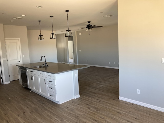 kitchen with a kitchen island with sink, sink, pendant lighting, and white cabinets