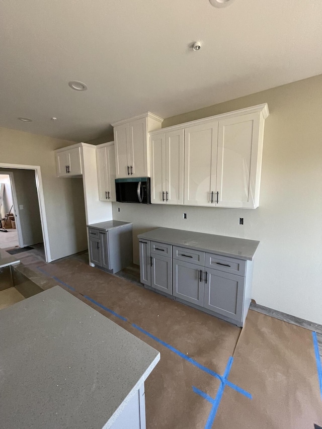 kitchen featuring white cabinetry, vaulted ceiling, and gray cabinetry