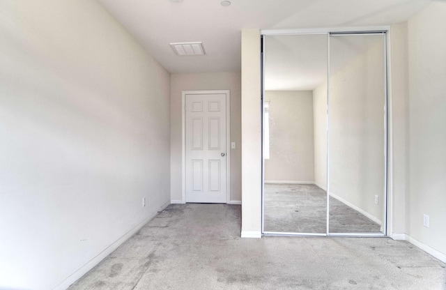 unfurnished bedroom featuring a closet and light carpet