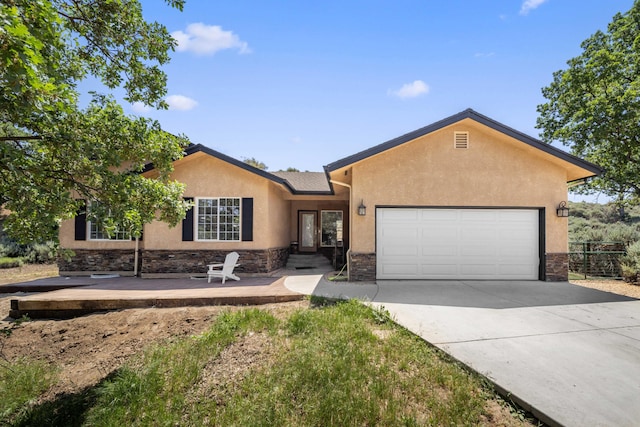 24481 Jacaranda Dr, Tehachapi, CA 93561 - ranch-style house featuring an attached garage, stone siding, stucco siding, and concrete driveway