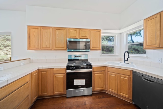 24481 Jacaranda Dr, Tehachapi, CA 93561 - kitchen with stainless steel appliances, a sink, dark wood-style floors, and tile counters