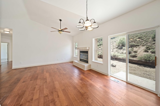 24481 Jacaranda Dr, Tehachapi, CA 93561 - unfurnished living room with wood finished floors, a chandelier, a tiled fireplace, high vaulted ceiling, and ceiling fan