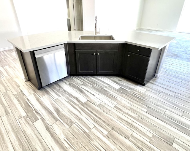 kitchen featuring stainless steel dishwasher, kitchen peninsula, and sink