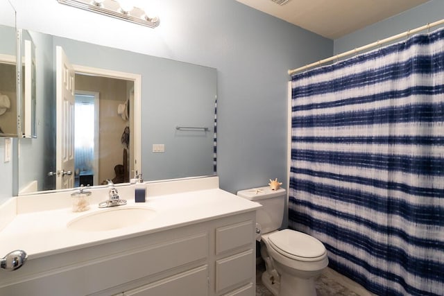 bathroom featuring vanity, a shower with shower curtain, and toilet