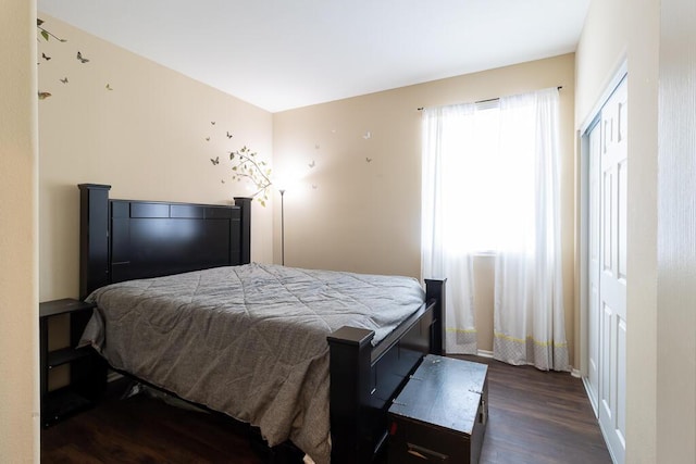 bedroom with a closet and dark hardwood / wood-style flooring