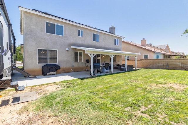 rear view of property featuring a lawn and a patio area