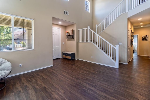 entryway with a towering ceiling and dark hardwood / wood-style floors