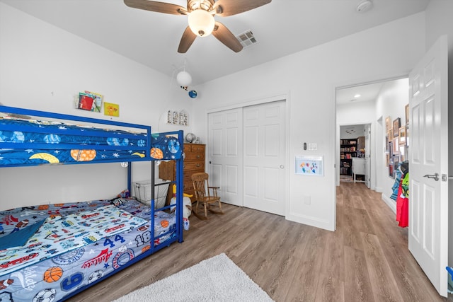 bedroom with a closet, light hardwood / wood-style flooring, and ceiling fan