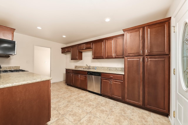 kitchen featuring light stone countertops, stainless steel appliances, a sink, and recessed lighting