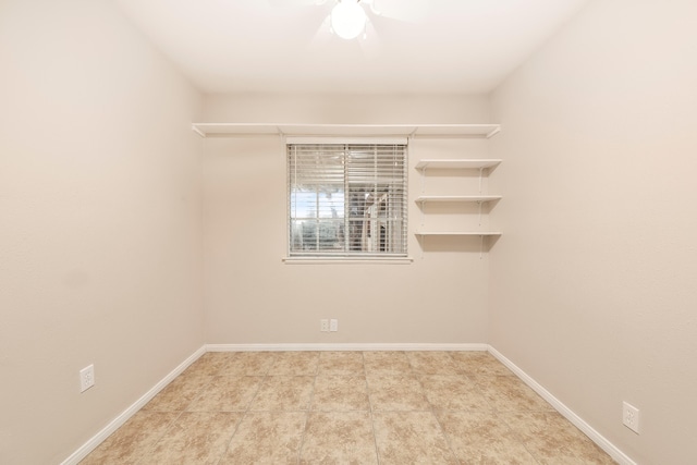 spare room featuring light tile patterned floors and baseboards