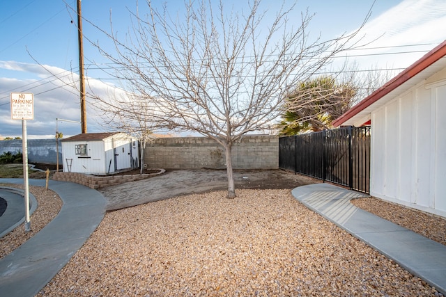 view of yard with an outbuilding, a storage shed, and a fenced backyard