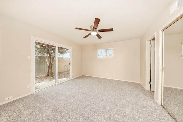 carpeted empty room featuring baseboards, visible vents, and ceiling fan