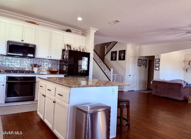 4011 Prestwick Ln, Palmdale, CA 93551 - kitchen with appliances with stainless steel finishes, crown molding, white cabinetry, backsplash, and dark wood finished floors