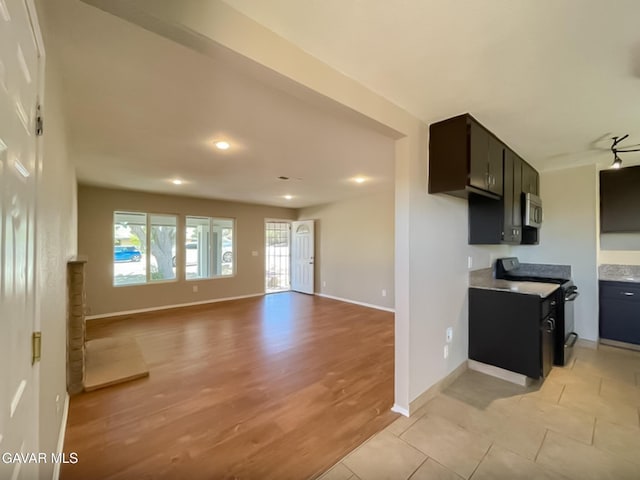 40205 E 162nd St, Palmdale, CA 93591 - kitchen with black range with electric stovetop, stainless steel microwave, light wood-style floors, recessed lighting, and light countertops