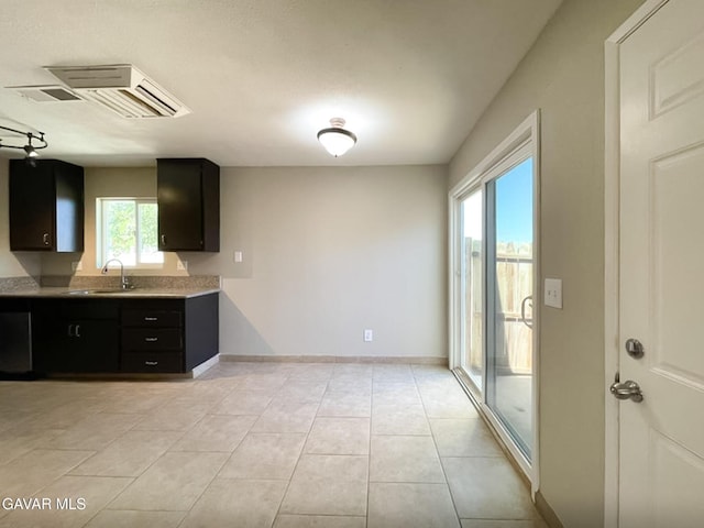 40205 E 162nd St, Palmdale, CA 93591 - kitchen with light countertops, dark cabinets, and light tile patterned floors
