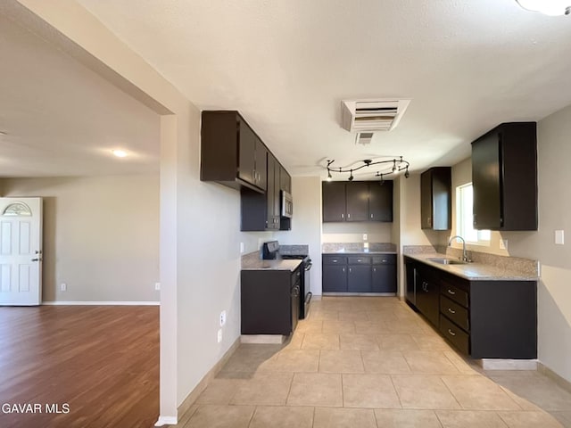 40205 E 162nd St, Palmdale, CA 93591 - kitchen with black range with electric stovetop, light countertops, stainless steel microwave, rail lighting, and light tile patterned floors
