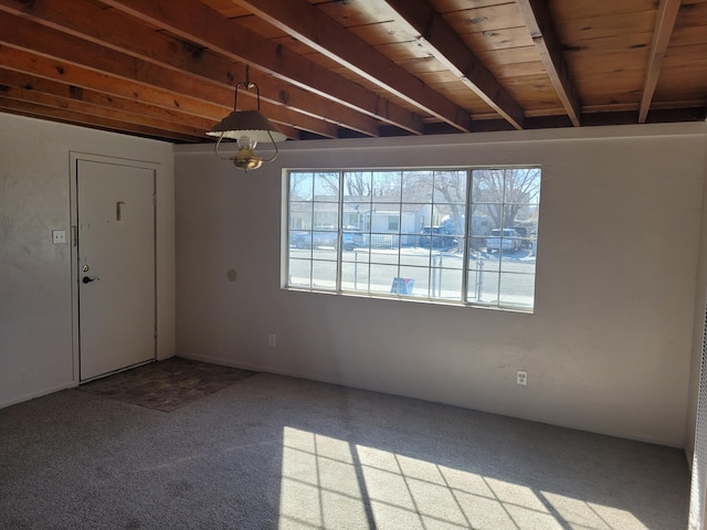 carpeted empty room featuring beam ceiling and wooden ceiling