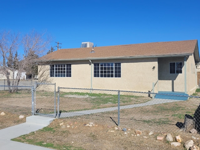 view of front facade with a gate, fence, and stucco siding