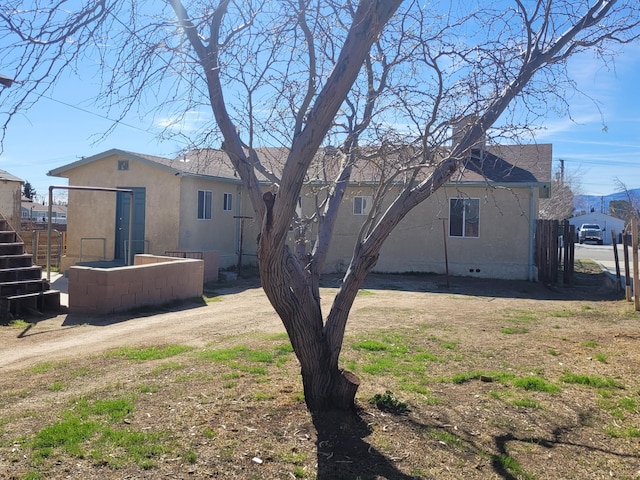 back of property with crawl space and stucco siding