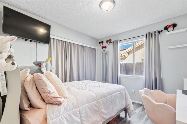 bedroom featuring a textured ceiling and wood finished floors