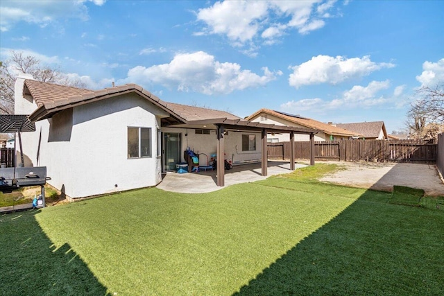 back of house with stucco siding, a yard, a fenced backyard, and a patio area