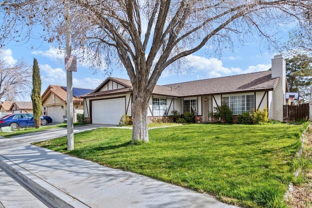 view of front of house with concrete driveway, a front yard, stucco siding, a chimney, and an attached garage