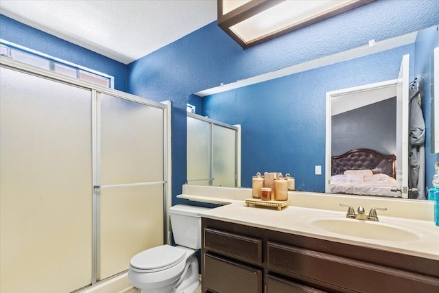 bathroom with vanity, a shower stall, ensuite bathroom, toilet, and a textured wall