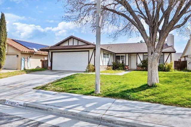 view of front of property with fence, a front yard, stucco siding, a garage, and driveway