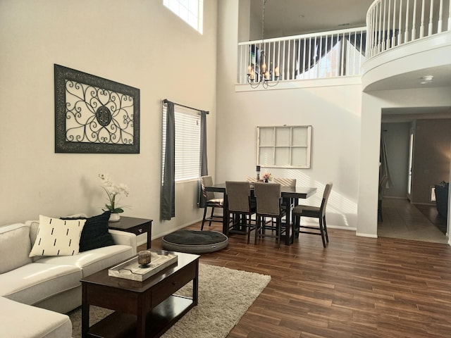 living room with dark wood-type flooring, a wealth of natural light, and a high ceiling