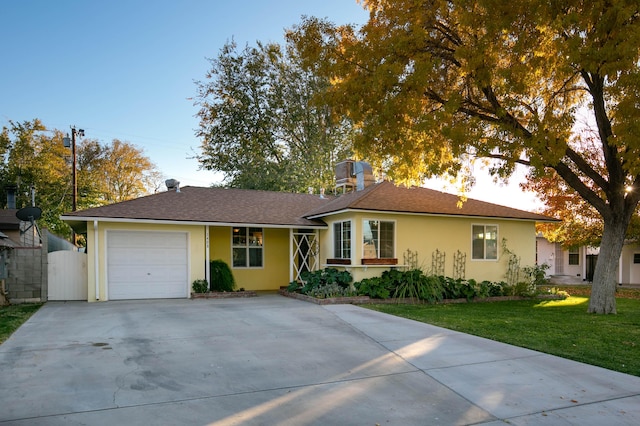 ranch-style home with a garage and a front lawn