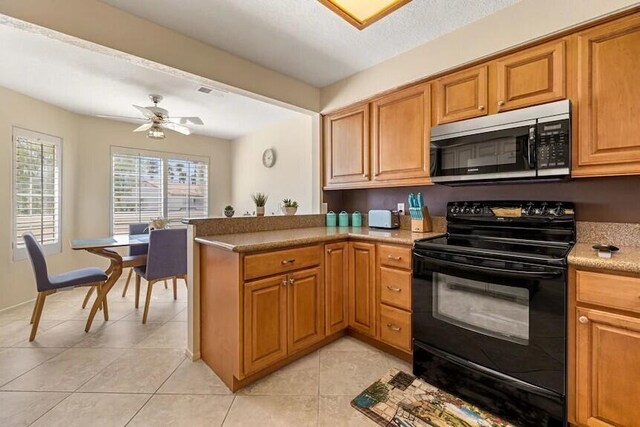 344 Vista Royal Dr, Palm Desert, CA 92211 - kitchen with a ceiling fan, electric range, light tile patterned floors, stainless steel microwave, and a peninsula