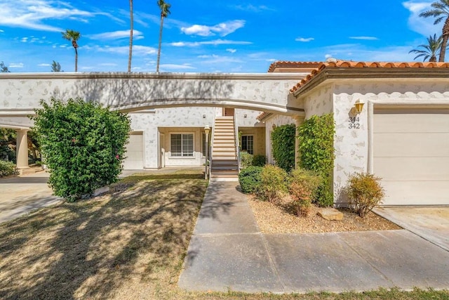 344 Vista Royal Dr, Palm Desert, CA 92211 - view of front of property with stucco siding, an attached garage, and a tiled roof