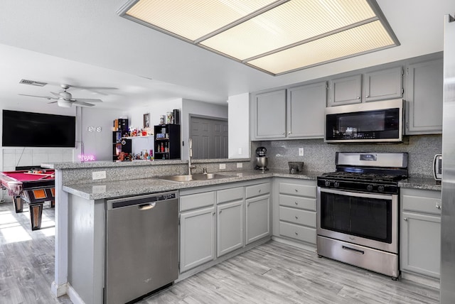 kitchen with sink, ceiling fan, gray cabinets, kitchen peninsula, and stainless steel appliances