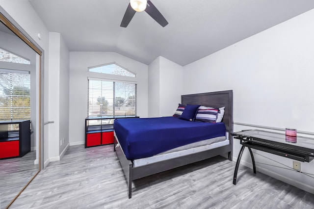 bedroom featuring ceiling fan, light hardwood / wood-style flooring, and lofted ceiling