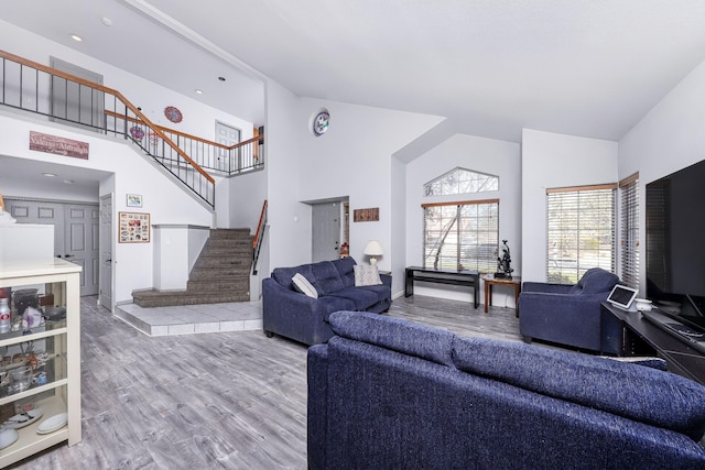 living room featuring wood-type flooring and high vaulted ceiling