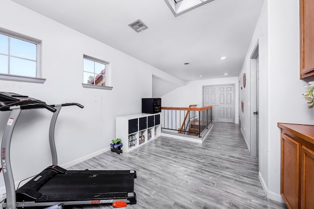 workout area with light hardwood / wood-style flooring