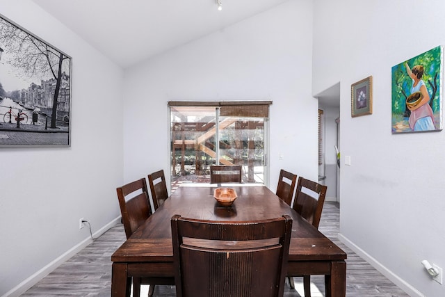 dining room featuring hardwood / wood-style flooring and vaulted ceiling