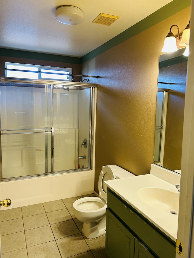 full bathroom featuring tile patterned floors, vanity, toilet, and enclosed tub / shower combo