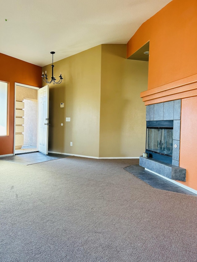 unfurnished living room with a chandelier, carpet, and a tile fireplace