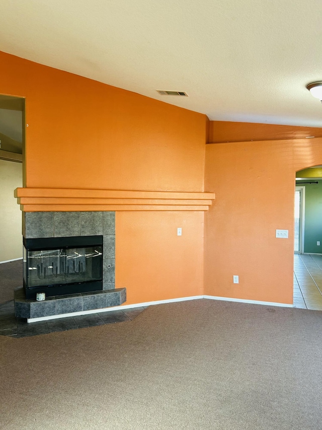 unfurnished living room with carpet and a fireplace