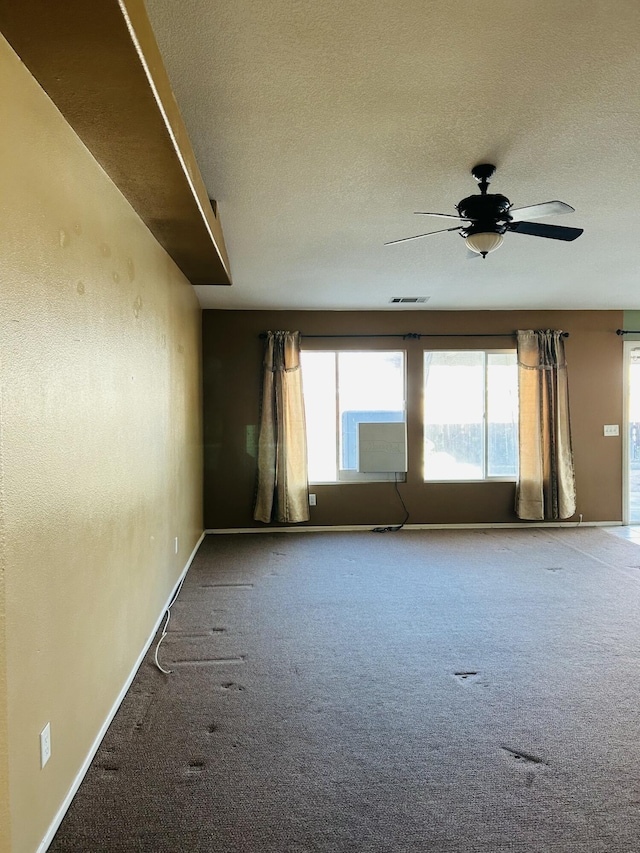 unfurnished room with carpet flooring, ceiling fan, and a textured ceiling